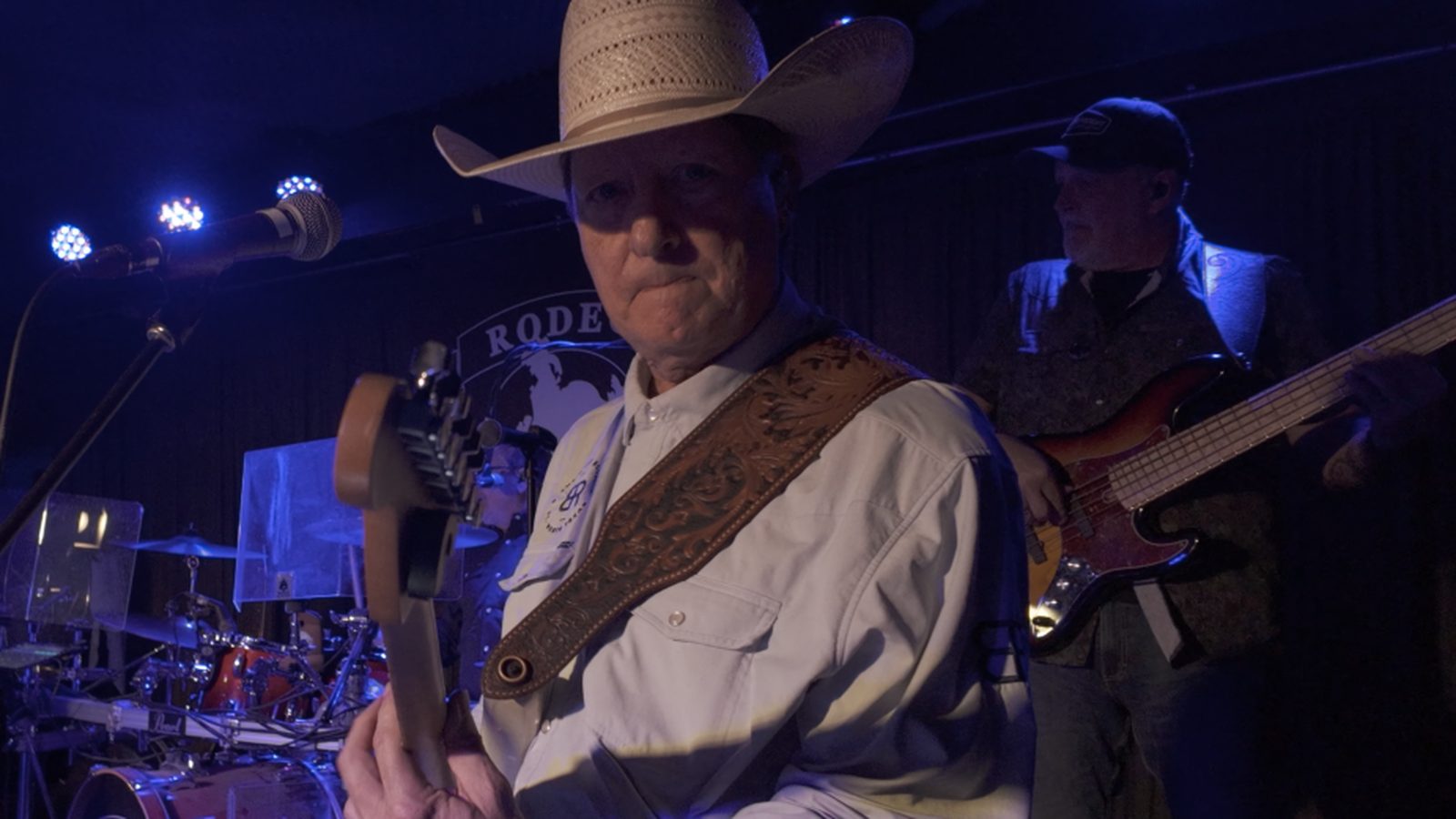 The bass player from Honkytonk U on the Rodeo Exchange stage, with another player behind him.