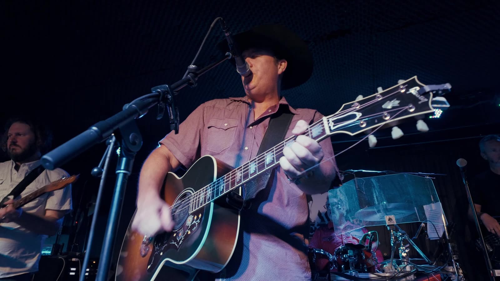 A singer and guitarist performing close up on the Rodeo Exchange stage.